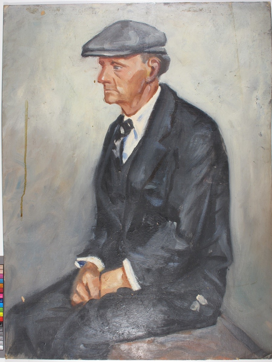 [Seated elderly man in grey suit]